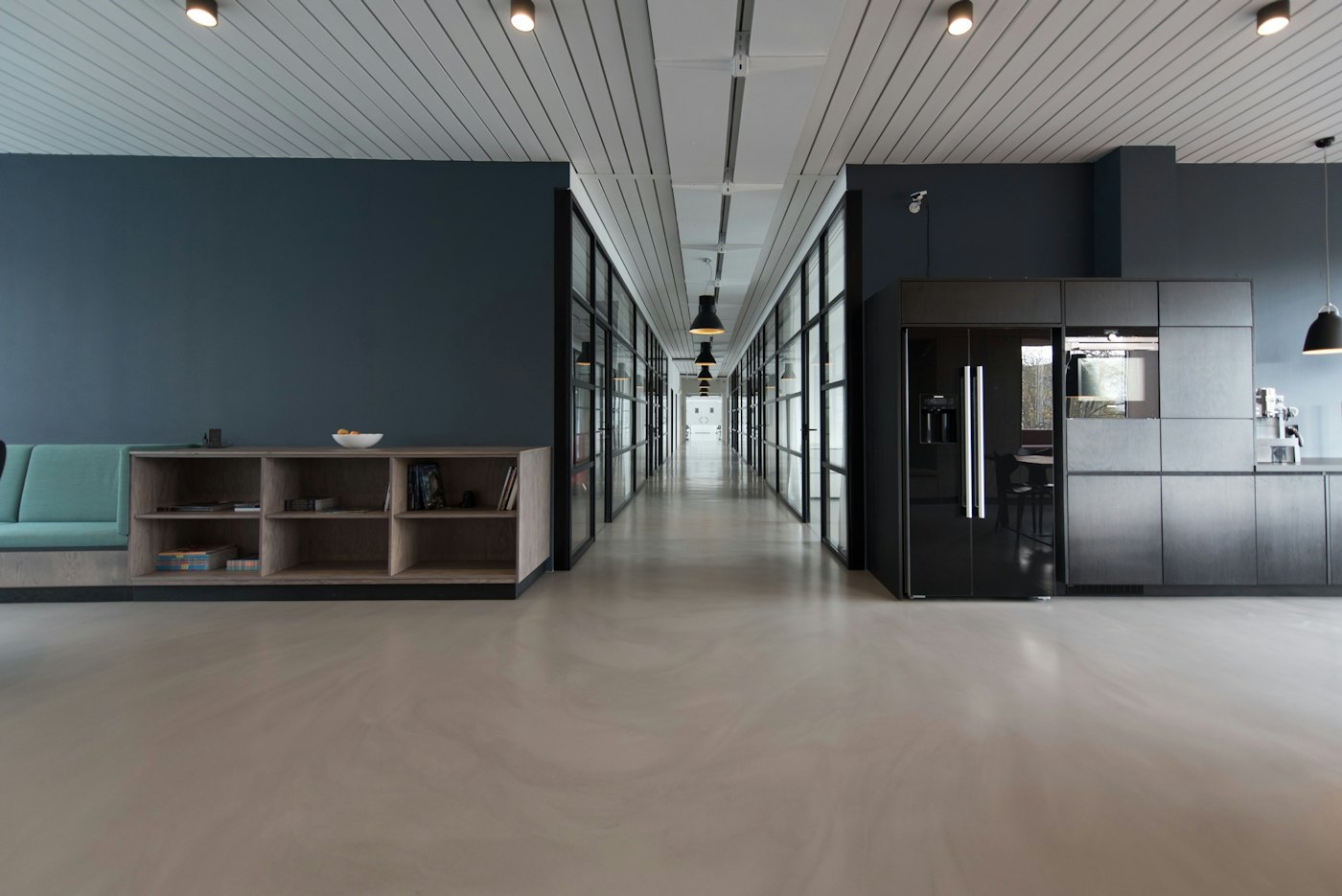 Office interior with dark walls, glass partitions and pantry unit